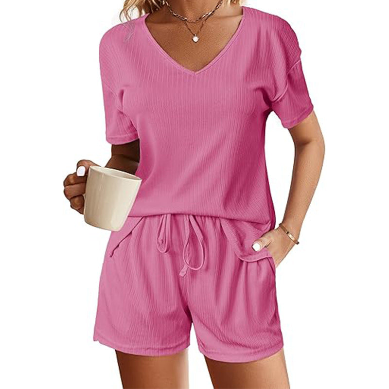 V-neck short sleeve shirt and matching shorts set in pink, featuring a drawstring and pockets.