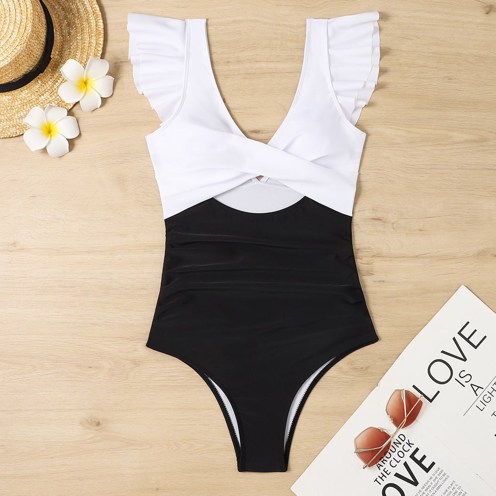 Criss-Cross One Piece Swimsuit with ruffled sleeves and cut-out detail on a wood surface.