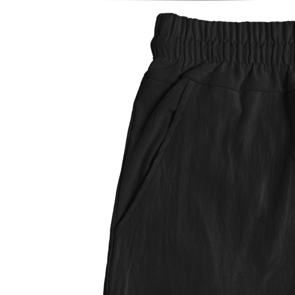 Men's black solid colour linen shorts with elastic waist and pockets.