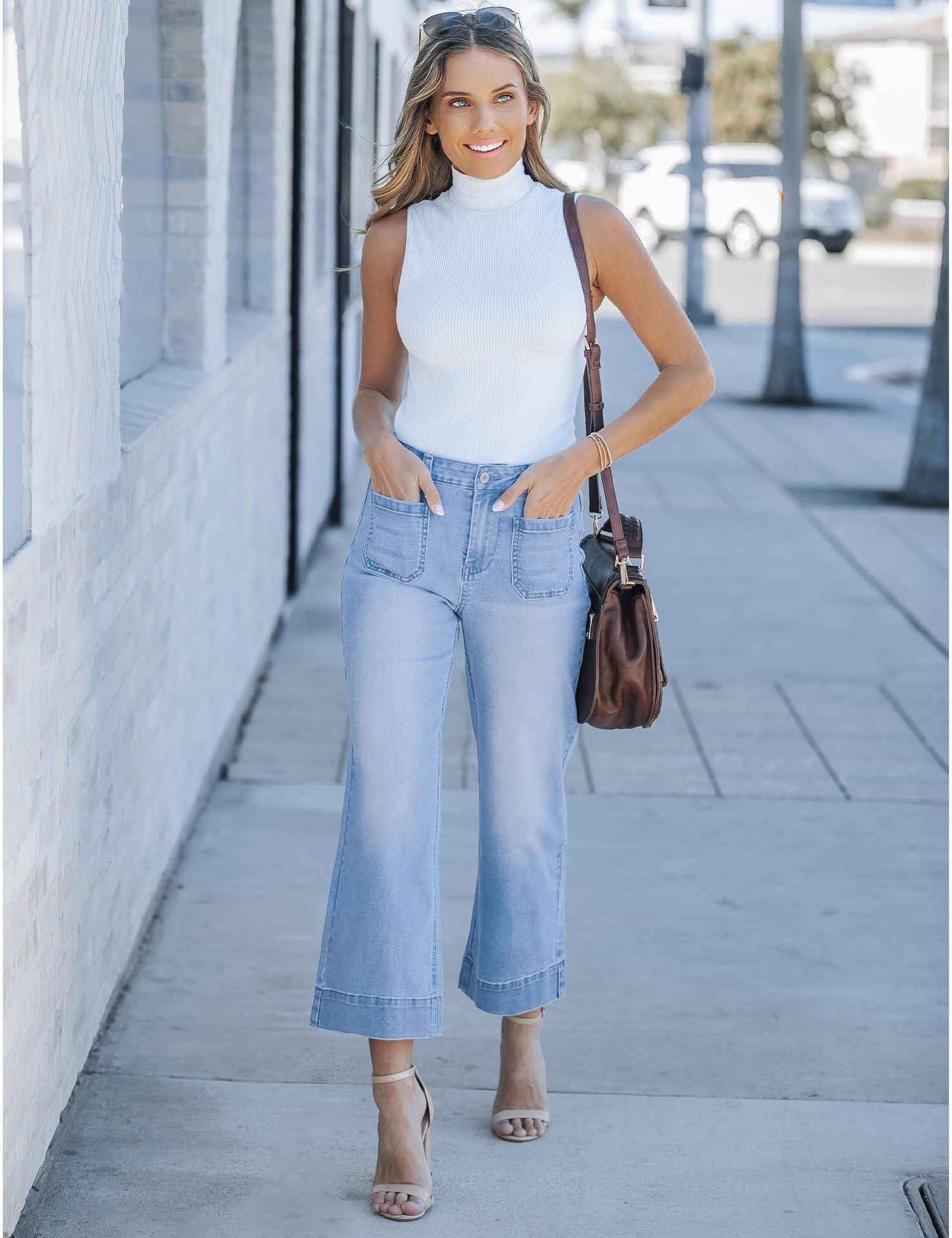 Wide leg cropped pants in light denim with front pockets, styled with a white sleeveless top.