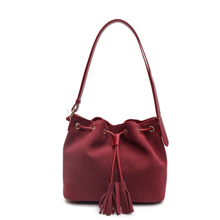 Stylish red bucket bag with tassel detail and shoulder strap.