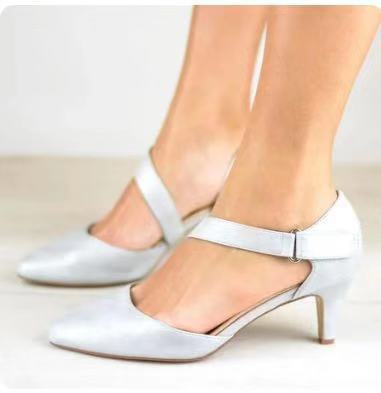 Pointed toe cross strap shoes with short stiletto heel in white PU leather for women.