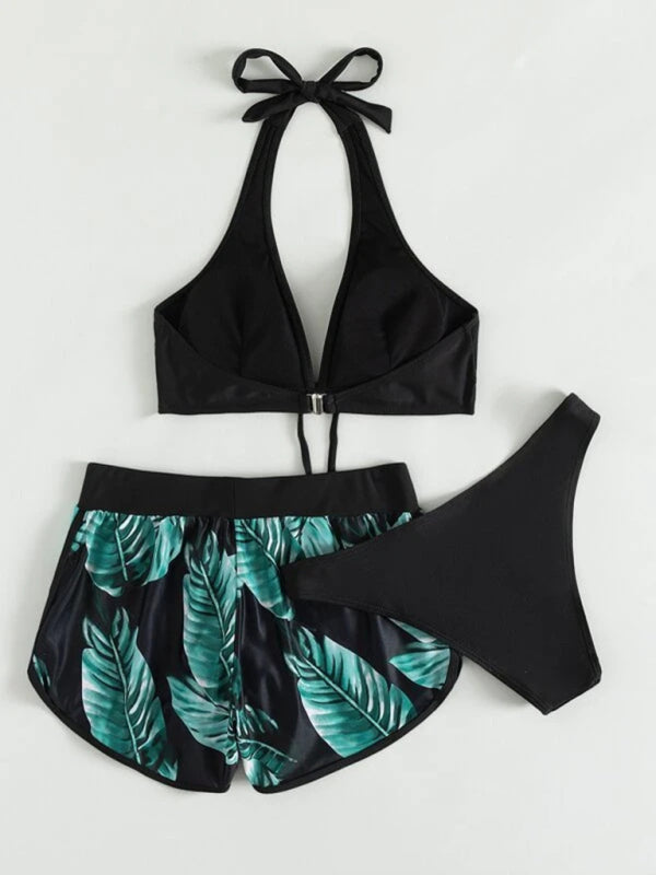 Women's tropical print halter neck bikini three-piece set with top, bikini bottoms, and swim shorts.