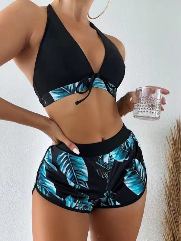 Women's tropical print halter neck bikini three-piece set with top and swim shorts.