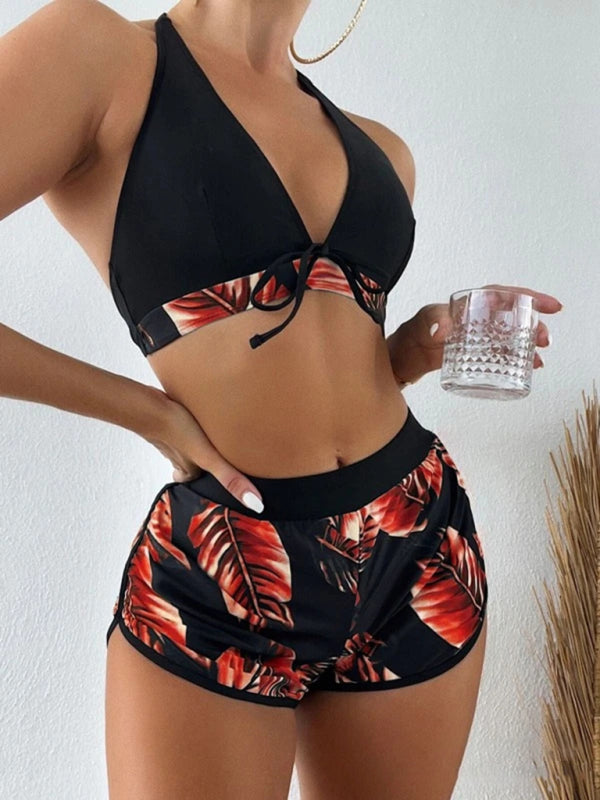 Women's tropical print halter neck bikini three-piece set with swim shorts.