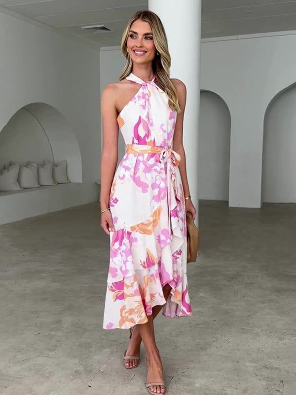 Sleeveless halter neck midi dress with pink and green floral pattern, asymmetric ruffled hem, and waist tie.