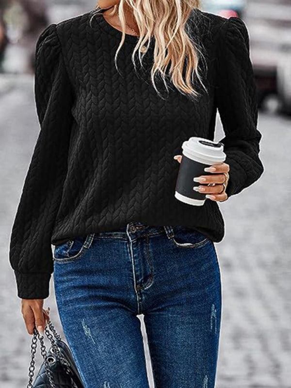 Women's black round neck patterned top with puffed long sleeves.