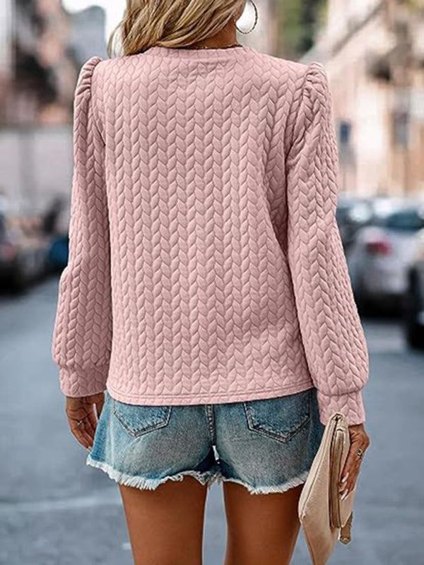 Women's round neck patterned top with puffed long sleeves, shown in a textured design on a model.
