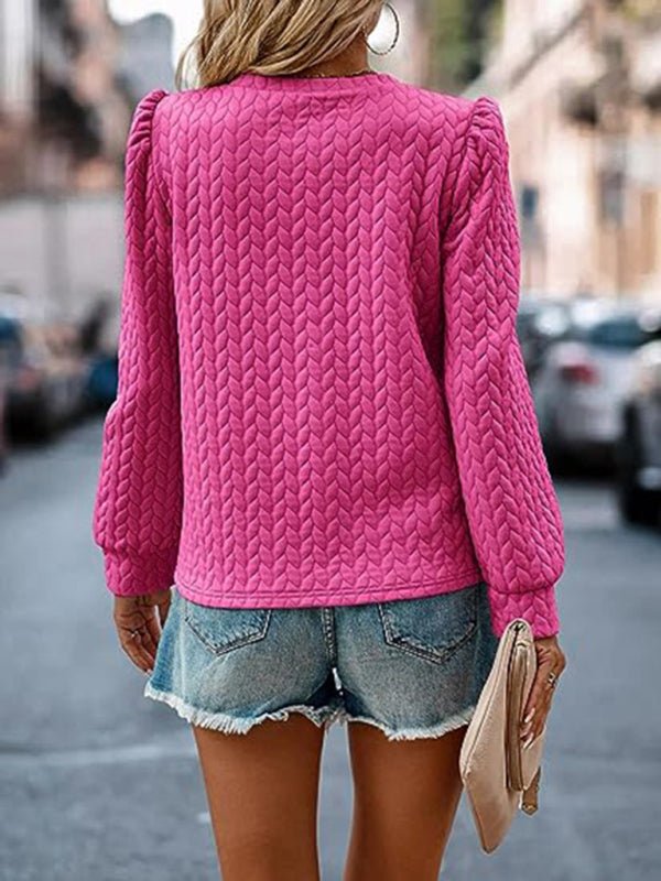 Women's round neck patterned top with puffed long sleeves, shown in vibrant pink.